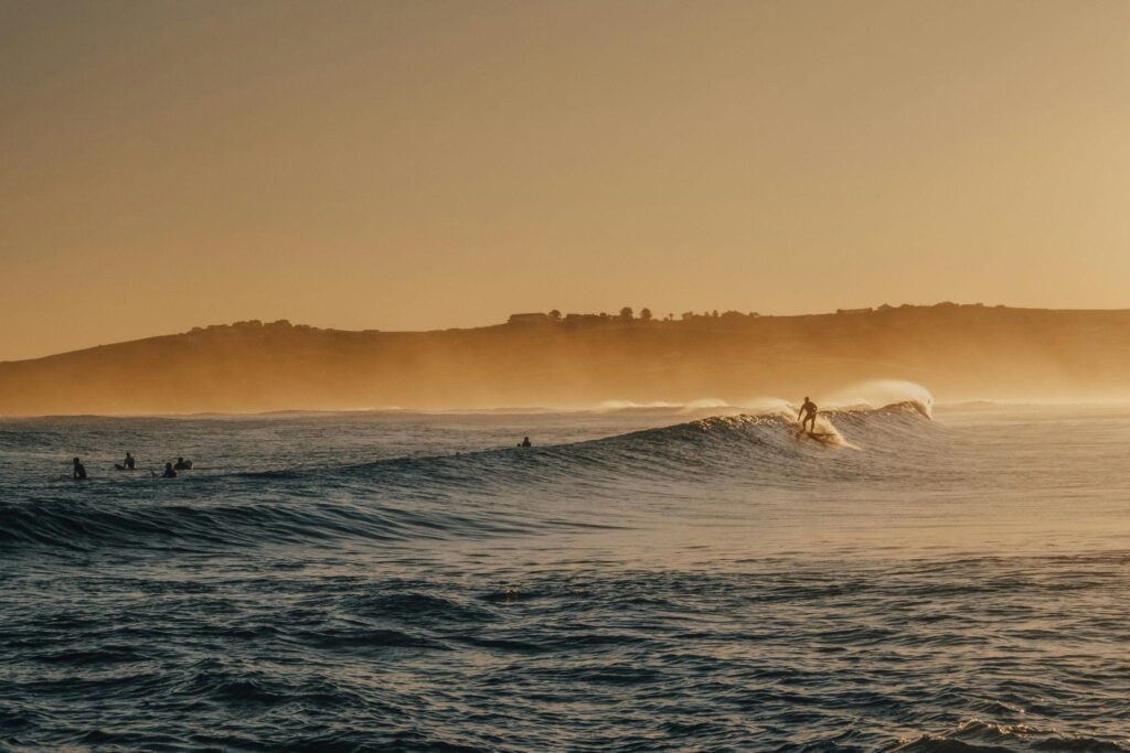 Mejores playas para surf en Cantabria | Hombre surfeando mientras muchos palean esperando | Grupo Jamsa